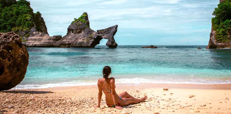 A girl sunbathsing on Atuh Beach Nusa Penida