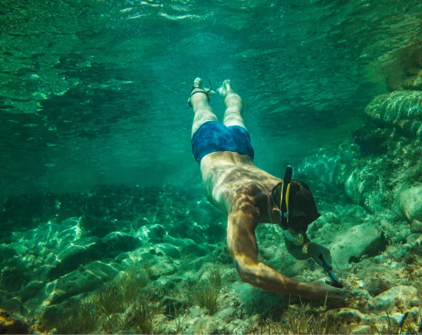 A man snorkeling on the shallow water on Tulamben dive site